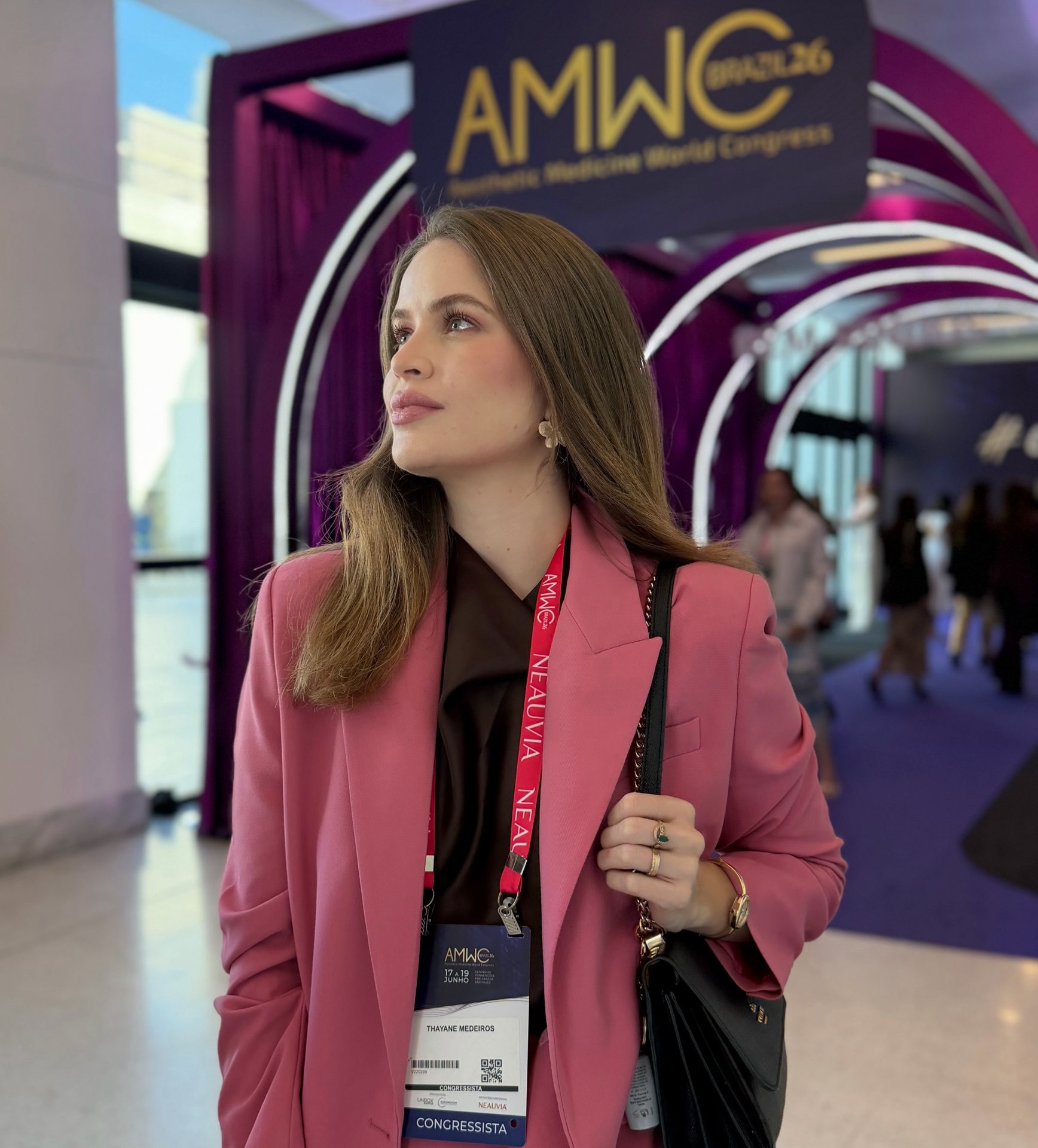 Dra. Thayane Fogaça na entrada do congresso AMWC, de crachá de congressista